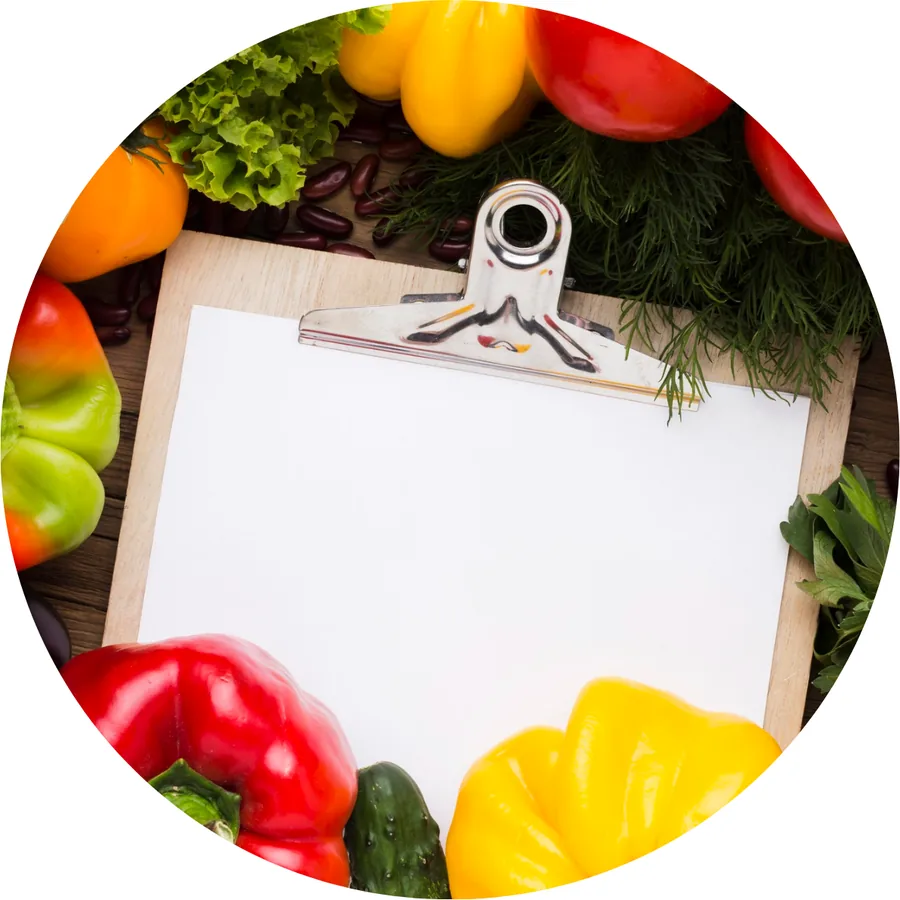Une ordonnance vierge sur une planche à pince, entourée de fruits et légumes frais